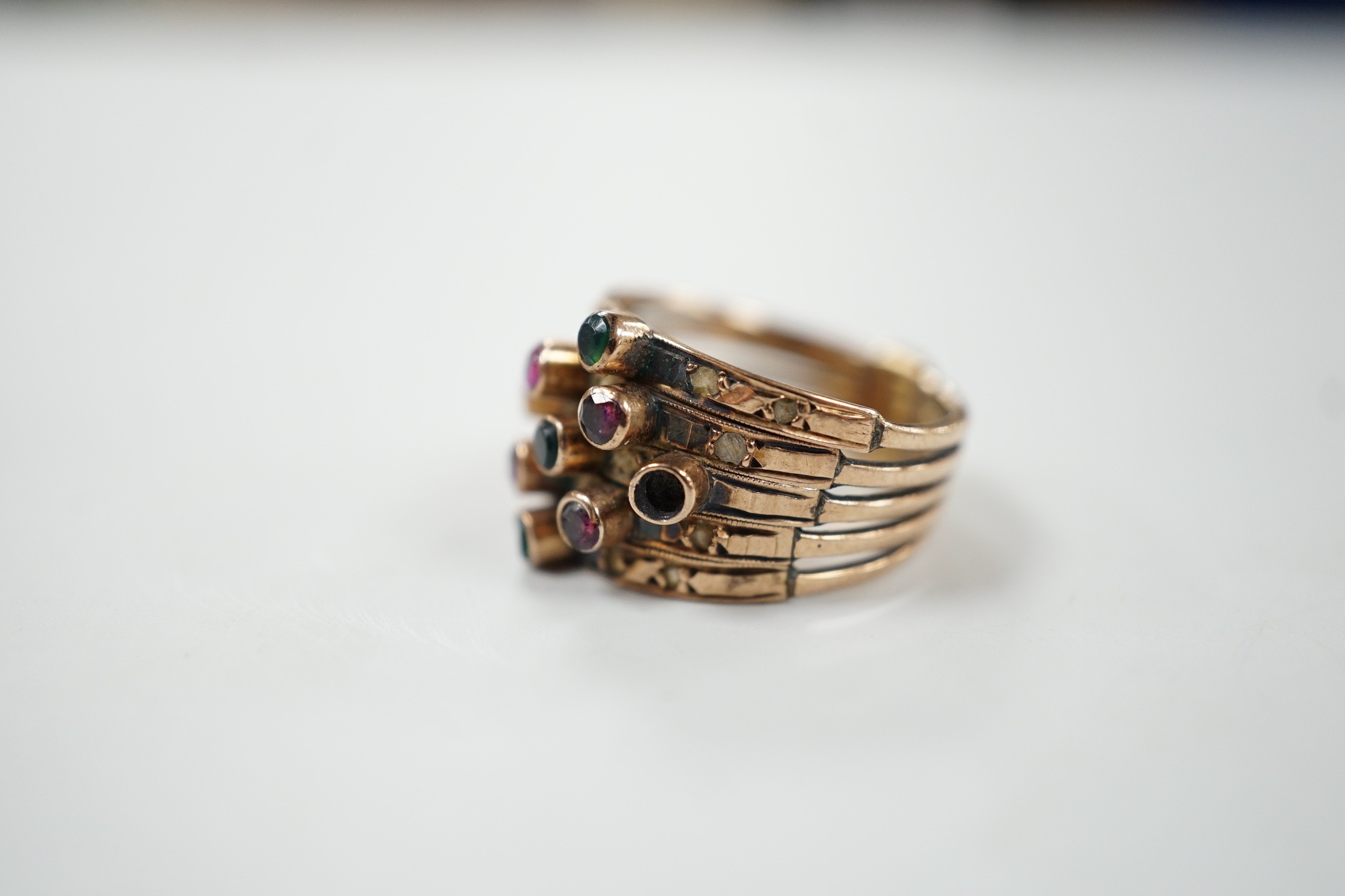 A yellow metal, quintuple band and multi gem set ring (stone missing), size H, gross weight 4.5 grams.